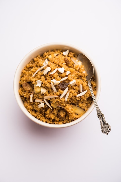 Foto wheat laapsi o lapsi o shira o halwa è un piatto dolce indiano a base di grano spezzato o pezzi di daliya e burro chiarificato insieme a noci, uvetta e frutta secca