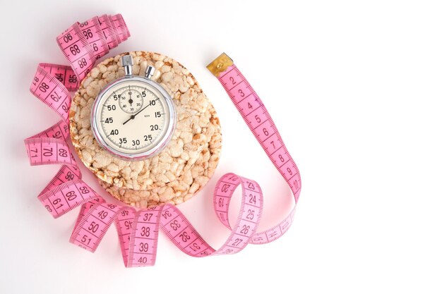 Wheat loaves measuring tape and a stopwatch on a white background
