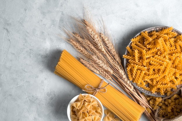 Photo wheat and pasta on a gray concrete background.