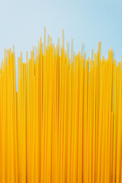 Wheat pasta spaghetti on a blue background. top view