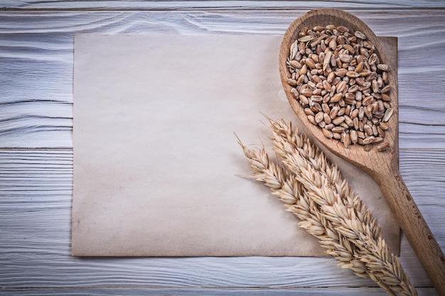 Wheat rye ears grain wooden spoon vintage paper on wood board