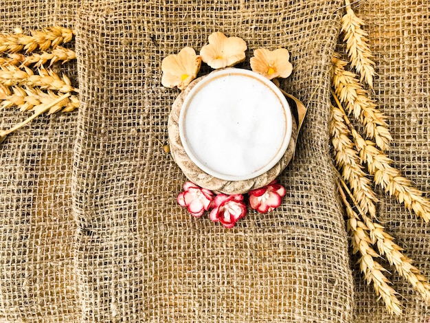 Wheat spikelets of straw and salt shaker with salt on an old brown rough canvas tablecloth