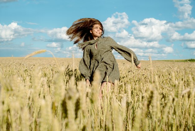 Germogli di grano in mano di un contadino coltivatore che cammina attraverso il campo che controlla il raccolto di grano