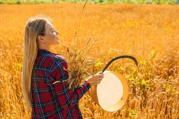 Photo wheat that is harvested and a a sieve sickle in the hands of a woman golden wheat background summer sunny day in ukraine copy space