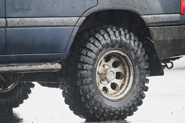 Wheel closeup in a countryside landscape with a muddy road