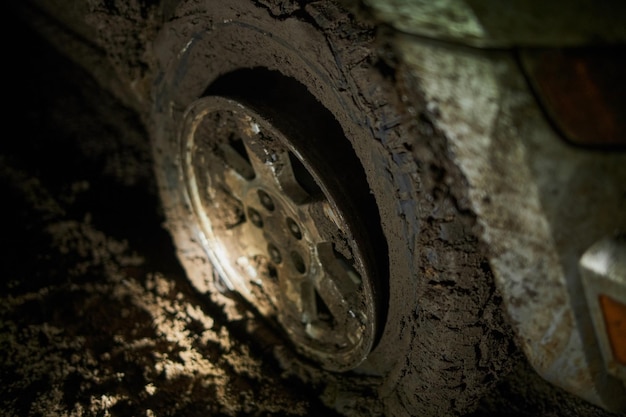 Wheel closeup in a countryside landscape with a muddy road