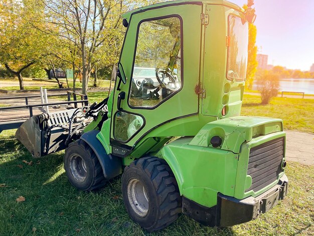 Photo wheel loader machinetractor on grassparkmunicipal works on reconstructionrenewal city recreation