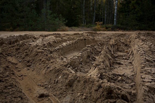 Wheel trail on sandy ground from large transport, tractor on construction site, sandy road. High quality photo