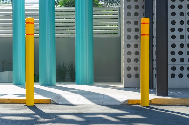 Photo wheelchair access ramp on a street with yellow safety posts surrounded by metallic elements