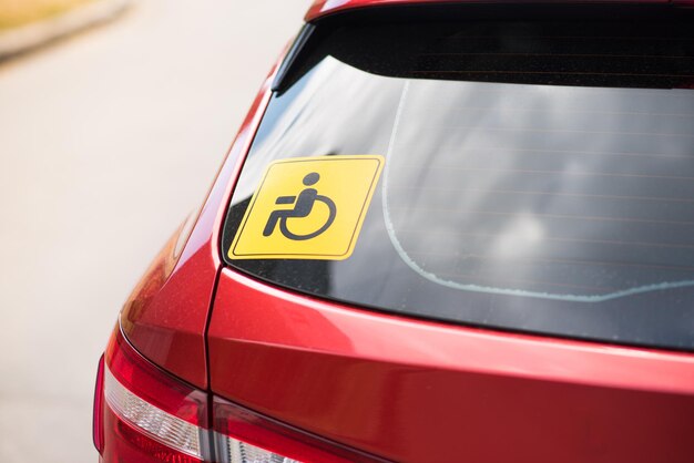 Wheelchair icon on the transport window disability badge on a\
red car