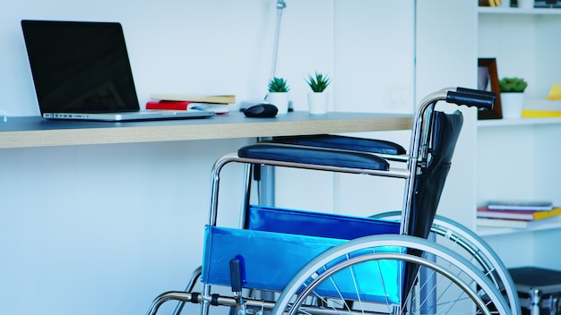 Wheelchair for people with mobility disability in empty room.