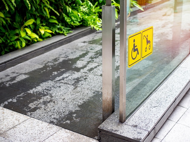 Wheelchair and stroller yellow sign and on the wall and ramp