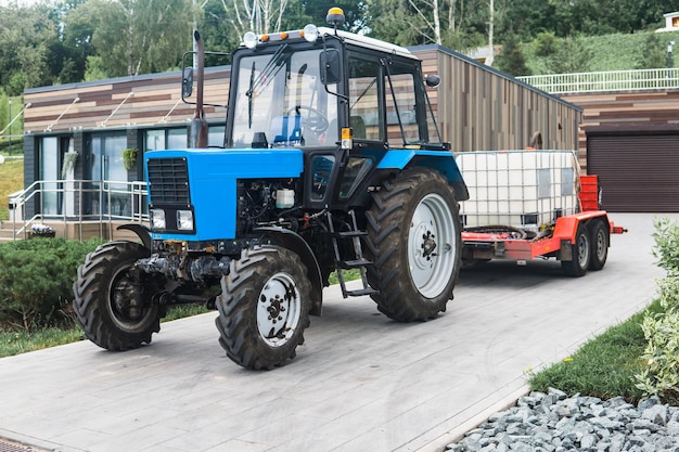 wheeled tractor with irrigation tanks on a trailer for maintenance of urban green spaces