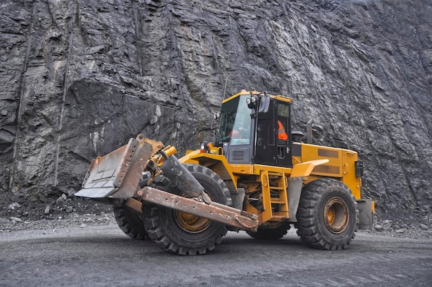 Photo a wheeled yellow bulldozer moves along the roads of an iron ore quarry quarry loader quarry road c