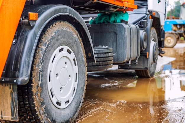 Wheels of a big truck in a mud puddle.