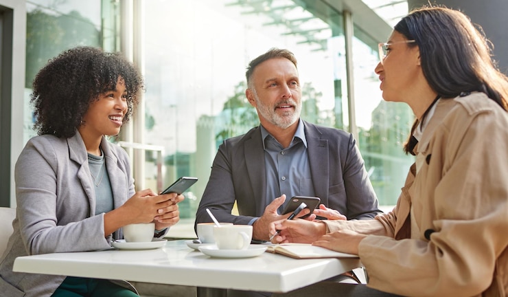 Photo when did you realise this shot of a group of colleagues brainstorming ideas at a coffee shop while using their smartphones