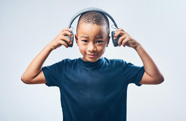 When I grow up I want to be a DJ Studio shot of a cute little boy using headphones against a grey background