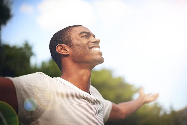 Photo when life smiles at you smile back shot of a man standing outside with his arms outstretched in delight
