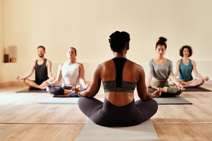 Photo when you believe you will receive shot of a group of young men and women meditating in the lotus position during a yoga session
