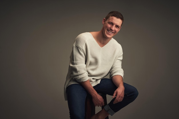 Photo where does he get his confidence from studio portrait of a cheerful young man seated against a grey background while looking at the camera