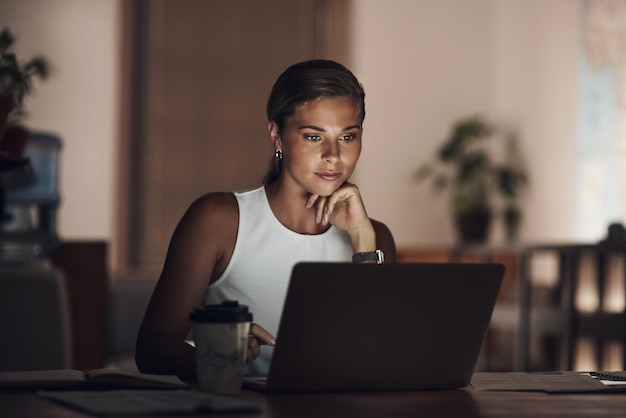 Dove c'è un duro lavoro, c'è un sacco di successo inquadratura di una giovane donna d'affari che usa un laptop durante una tarda notte di lavoro