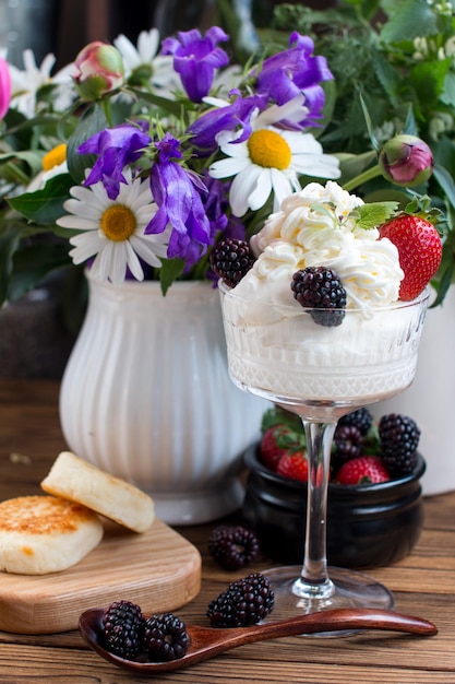 Фото Взбитые сливки в стакане с ягодами сладкий десерт с клубникой и ежевикой