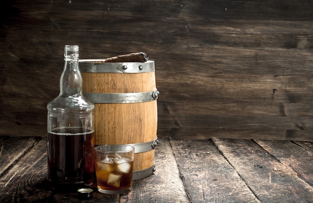 Whiskey background. A barrel of Scotch whiskey with glass and a cigar.