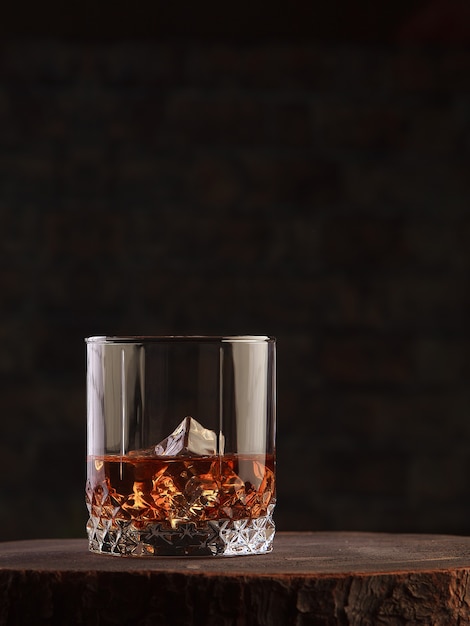 Photo whiskey drink on dark wooden table