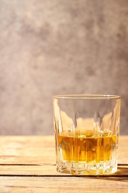 Whisky in primo piano servito senza ghiaccio su tavola di legno