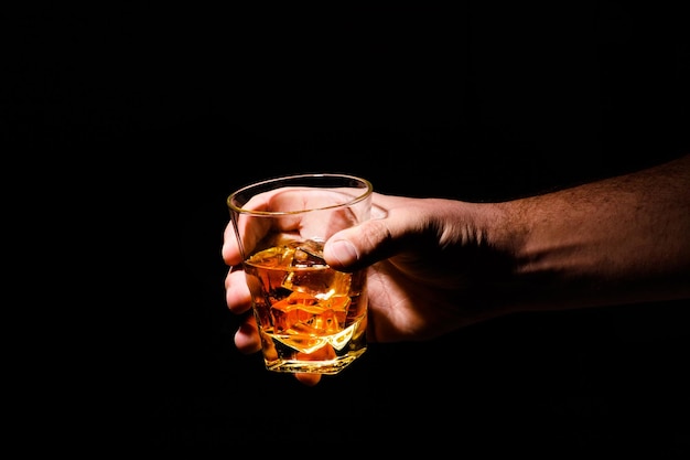 Whiskey glass in a hand of a man