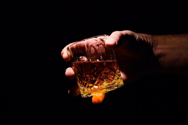 Whiskey glass in a hand of a man