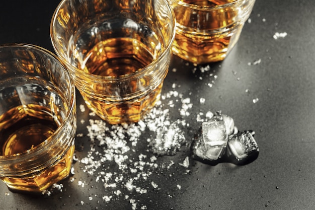 whiskey and ice on rustic wood background