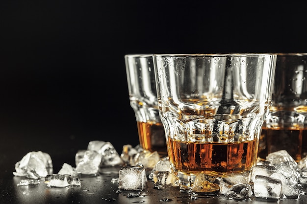 Whiskey and ice on rustic wood background