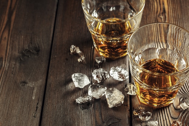 Whisky e ghiaccio su legno rustico