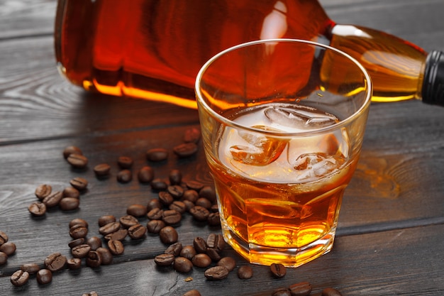 Whiskey or liqueur, coffee beans and orange cut on wooden . Seasonal holidays .