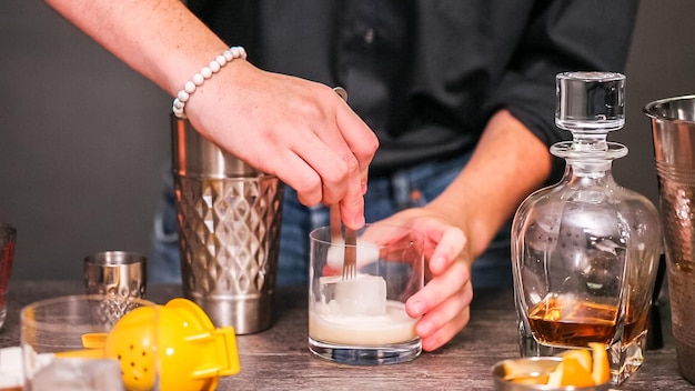 Whiskey sour cocktail garnished with orange and cherry.