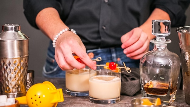 Whiskey sour cocktail garnished with orange and cherry.