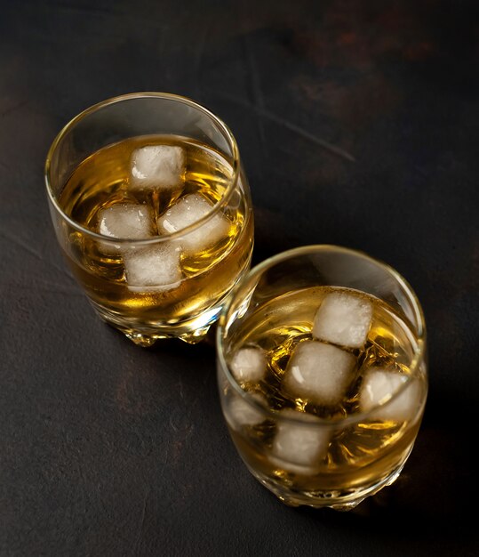 Whiskey with ice on the concrete, top view