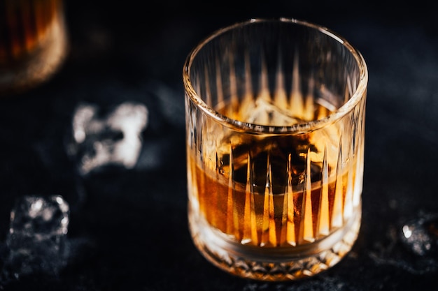 Whiskey with ice on a dark table