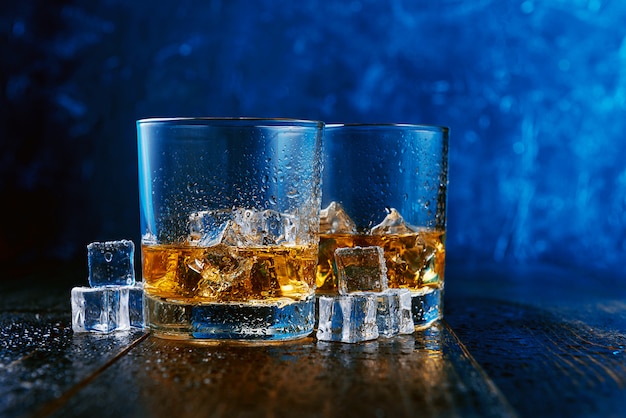 Whiskey with ice in modern glasses