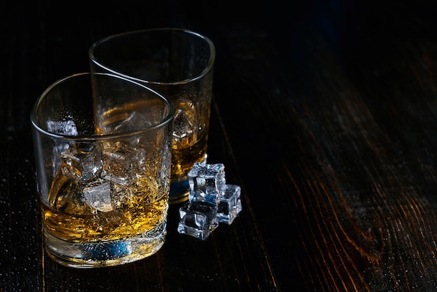 Whiskey with ice in modern glasses