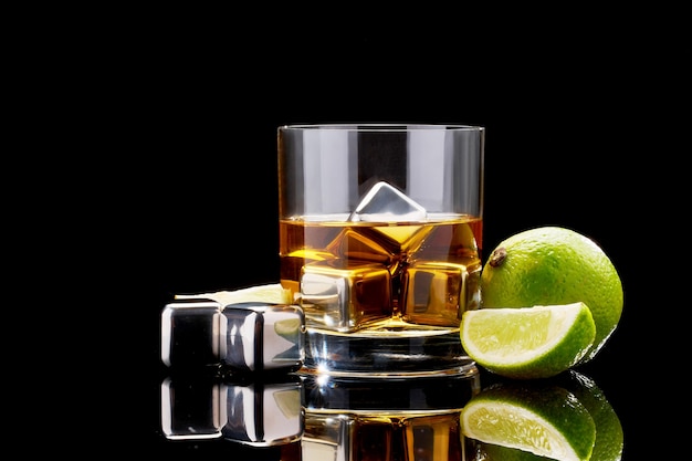whiskey with steel cooling cubes on glass on dark surface