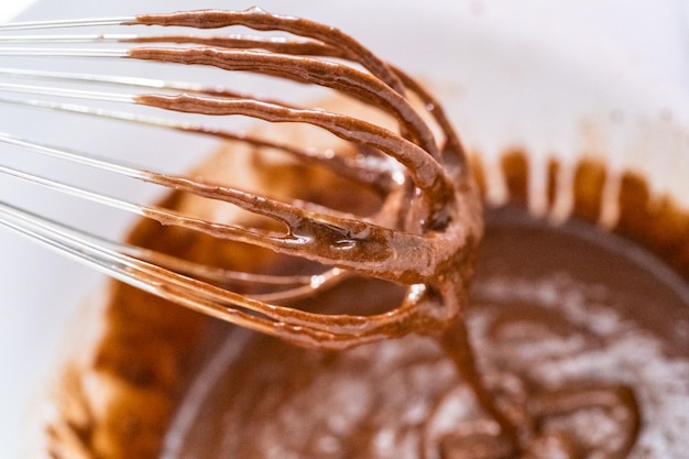 Whisking batter for chocolate cupcakes in a mixing bowl.