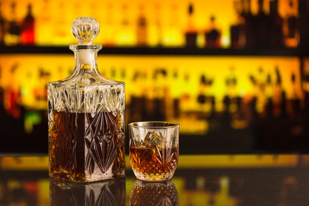 Whisky bottle and glass on bar counter