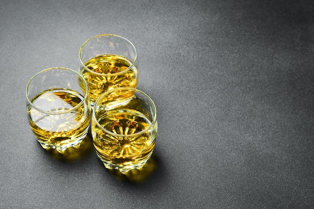 Whisky in een glas Drie glazen whisky of bourbon op een donkere tafel Sterke alcoholische dranken