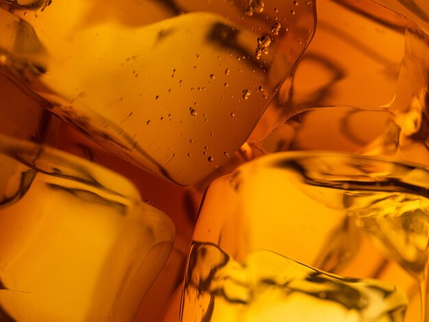 Whisky on the rocks glass filled with ice cubes closeup shot