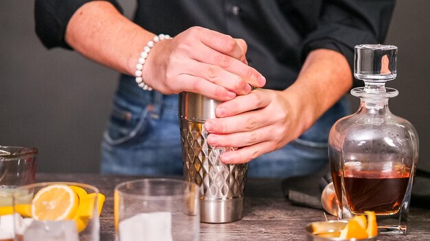 Whisky zure cocktail gegarneerd met sinaasappel en kersen.