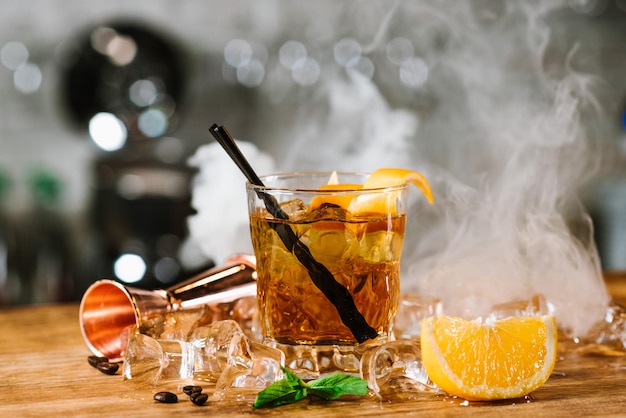 Whiskycocktail met een rook genaamd smoking gun aan de bar