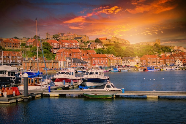 Whitby abbey is a seaside town and port at sunset in North Yorkshire, UK