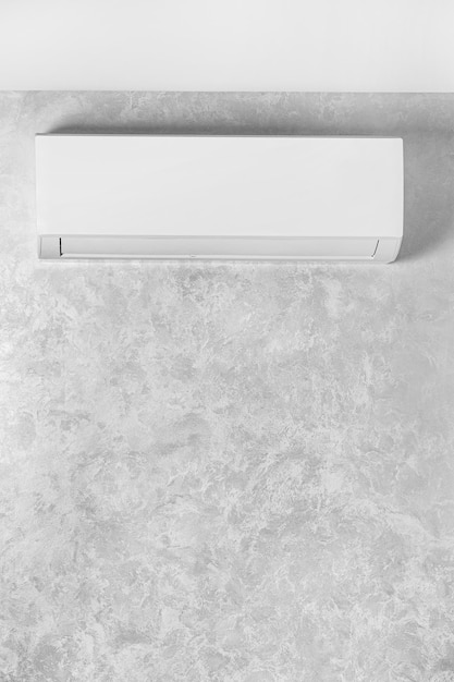 Photo white air conditioner on a gray wall in a house apartment